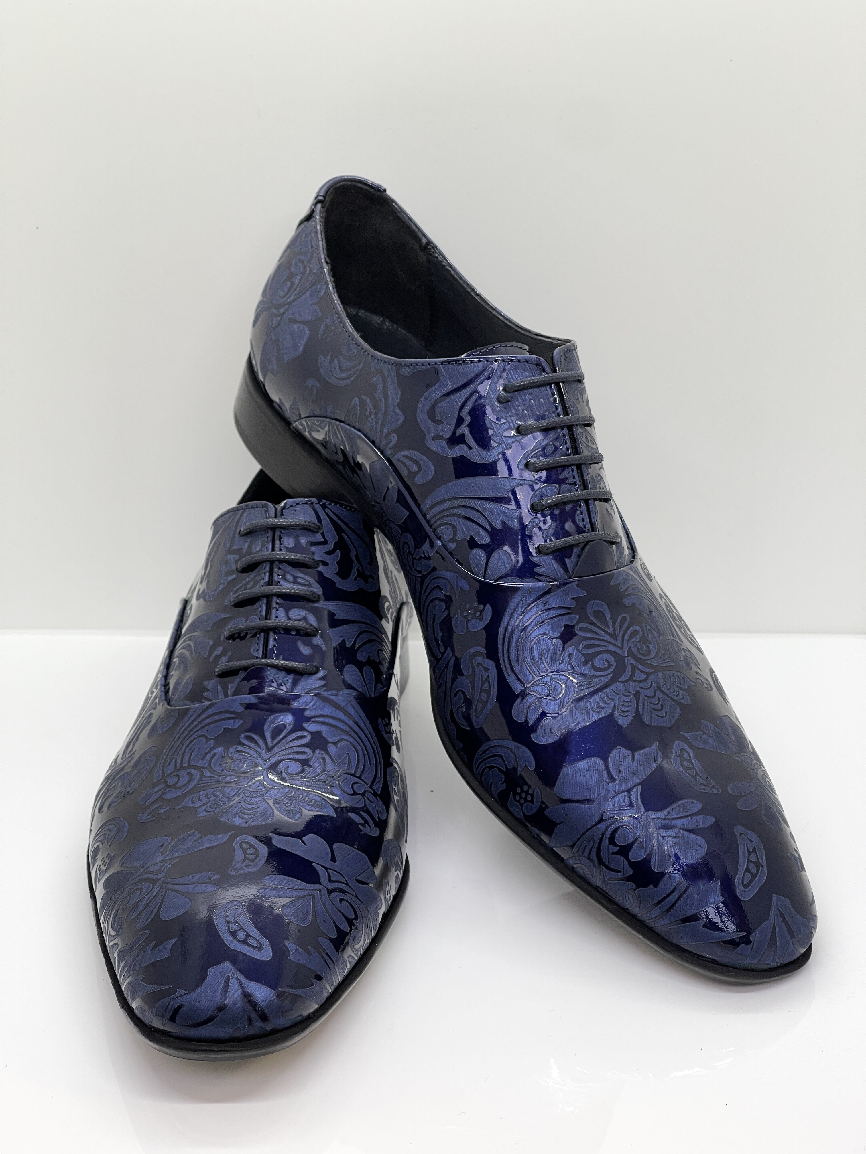 Handgefertigter Herrenschuh aus echtem Leder mit einer filigranen Lasergravur in Form von Paisley-Ornamenten und eleganten Lackdetails in Blau.